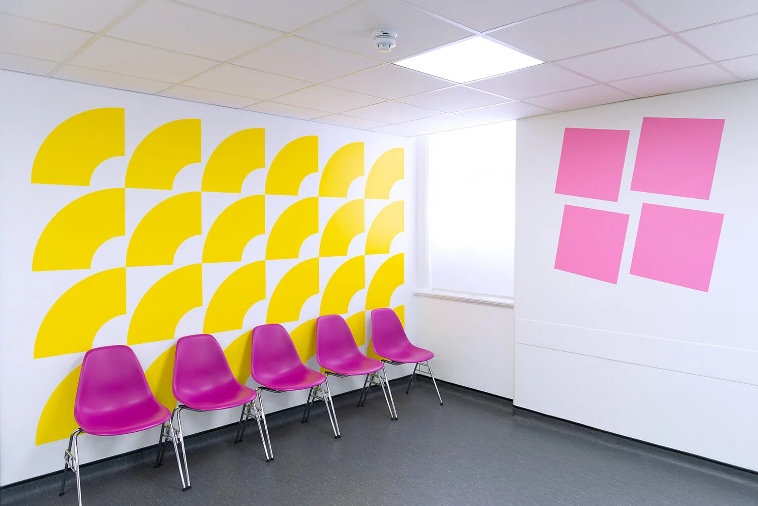 Yellow pattern and pink chairs in a waiting area