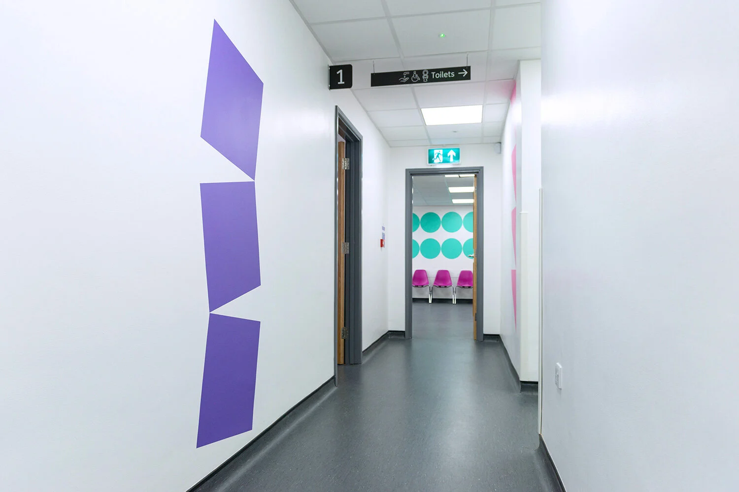 Purple geometric landmark beside a hospital corridor