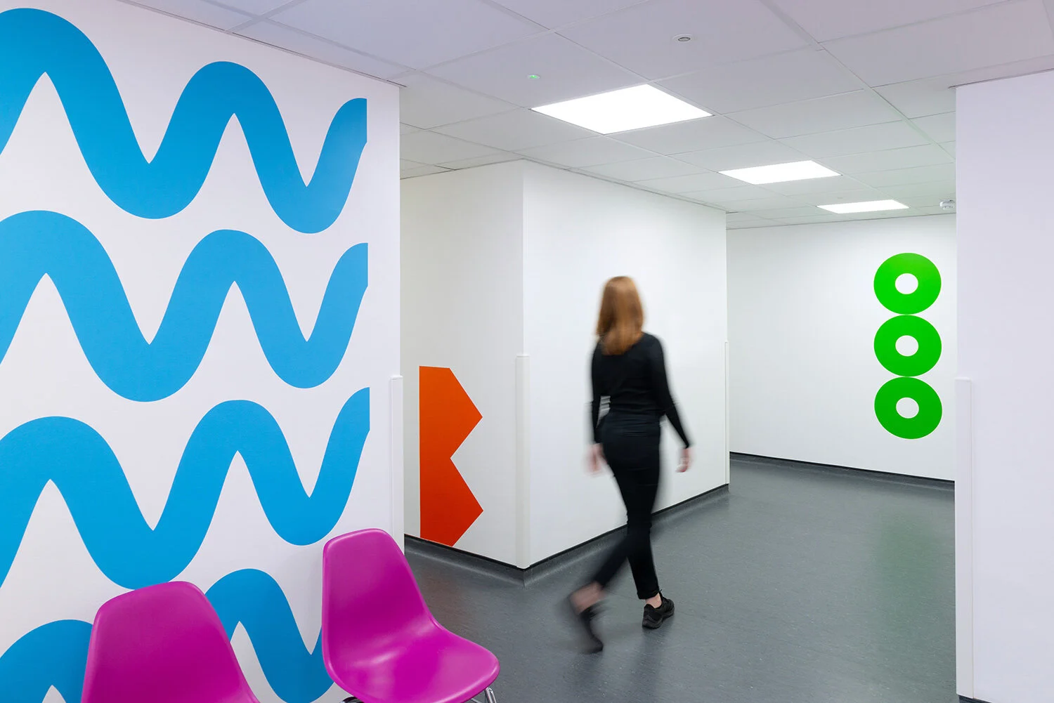 Blue wave landmarks and a visitor moving through the Royal London Hospital