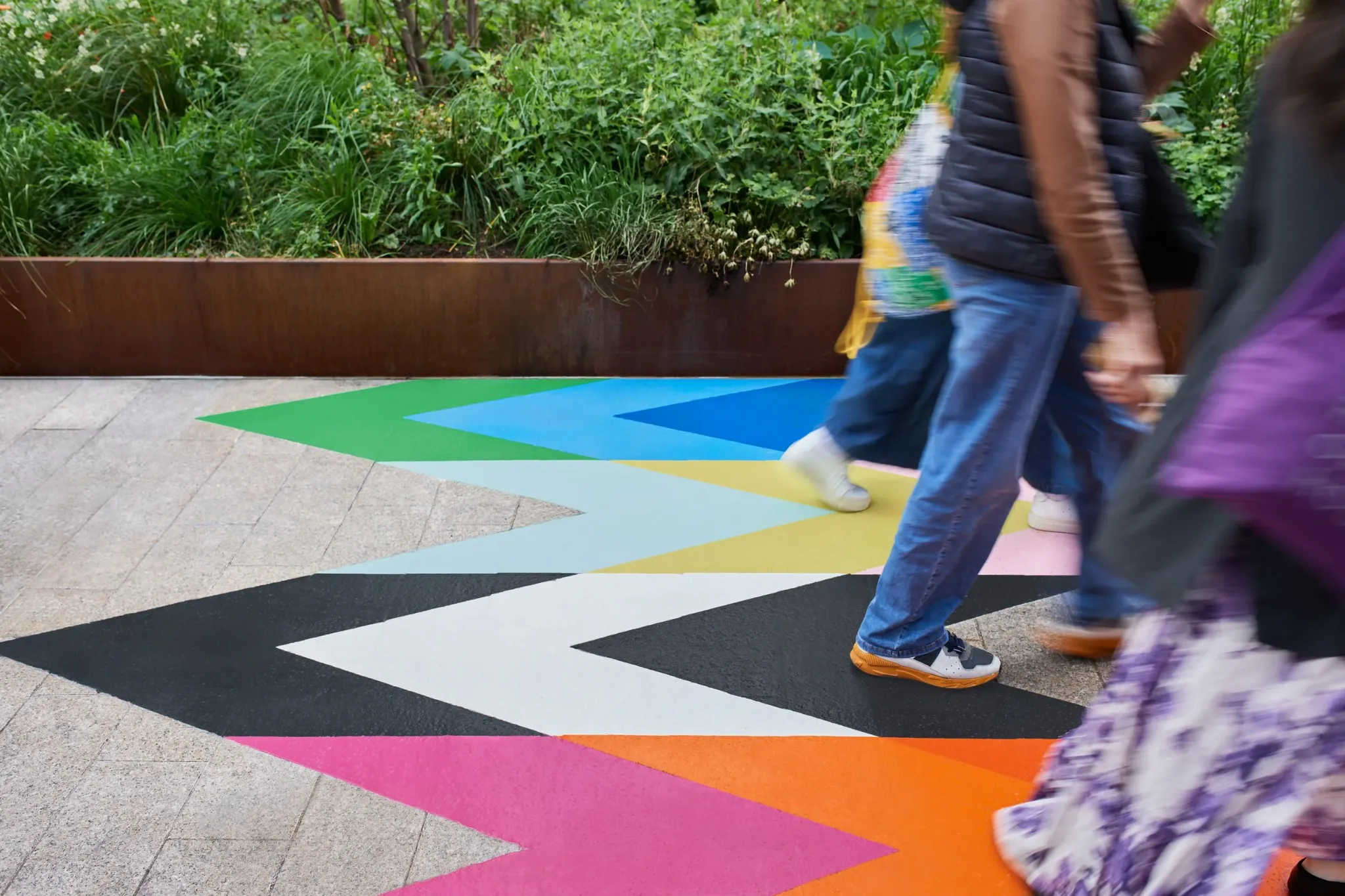People walking across the colourful Intersection artwork