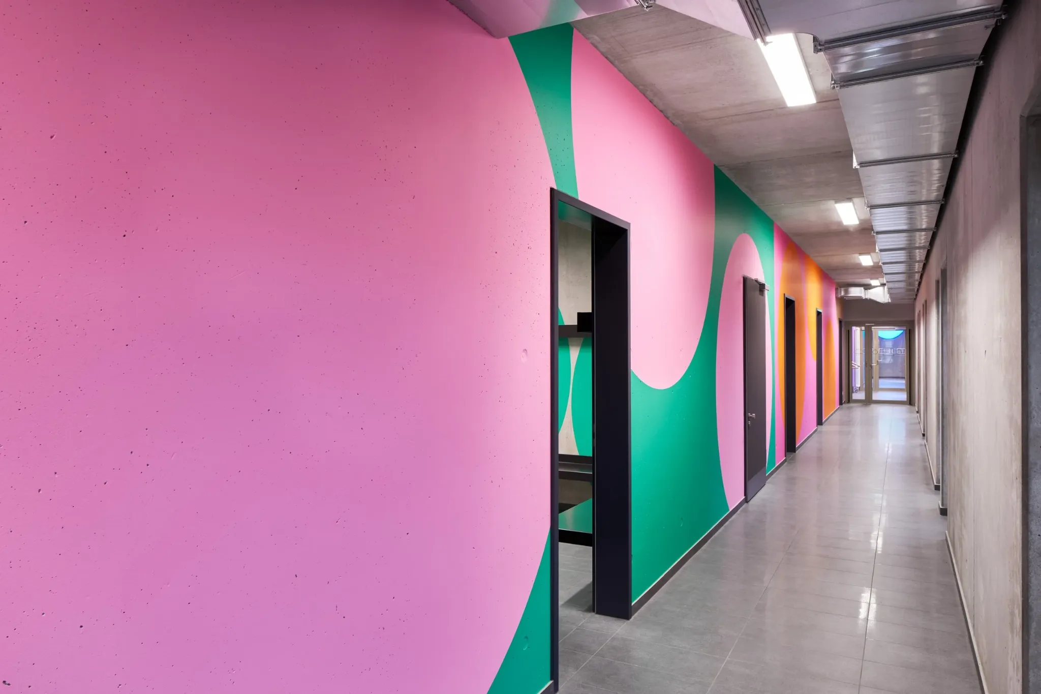 Pink and green colour-led corridor at the We Play sports centre