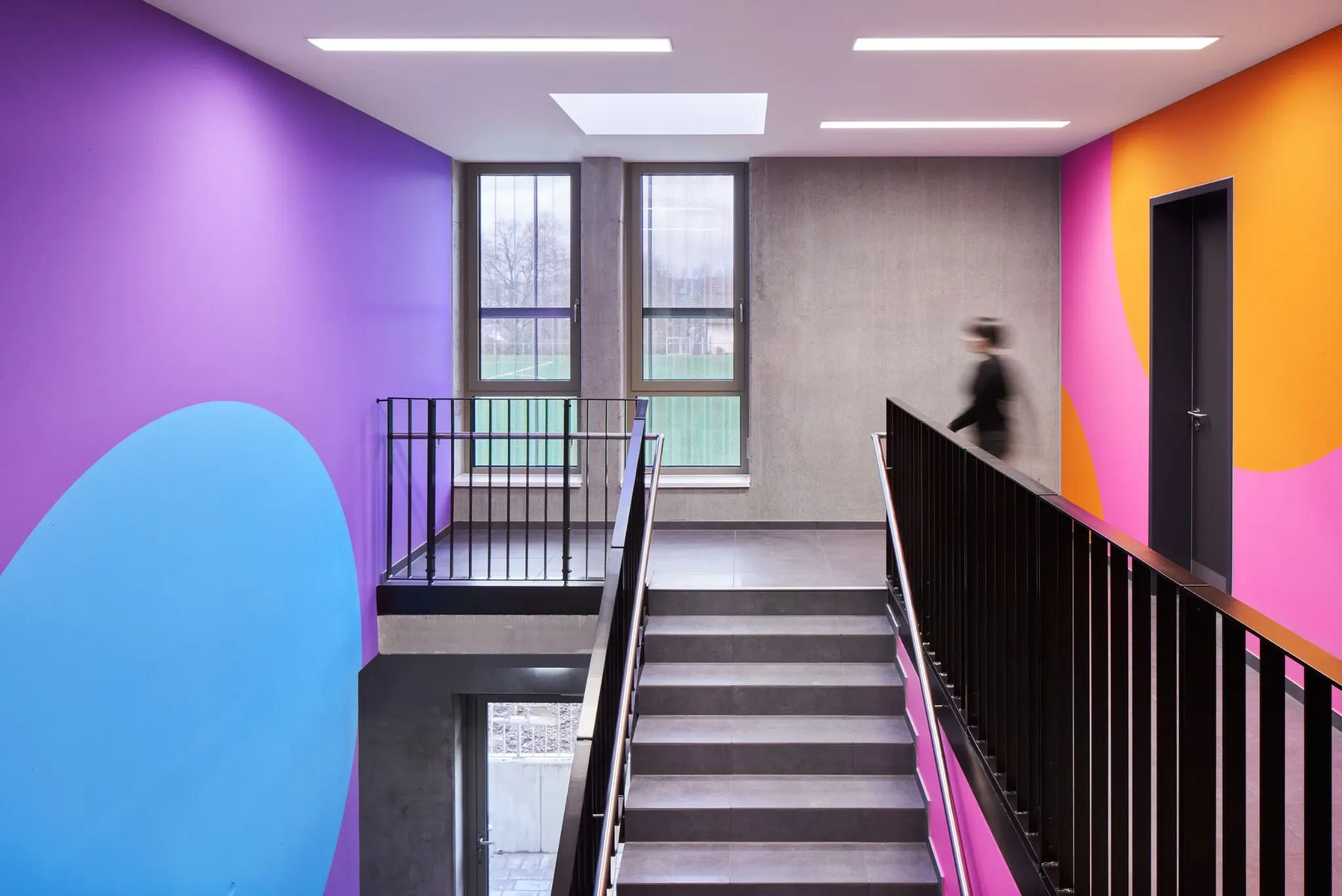 Purple and orange geometric wayfinding artwork around a staircase