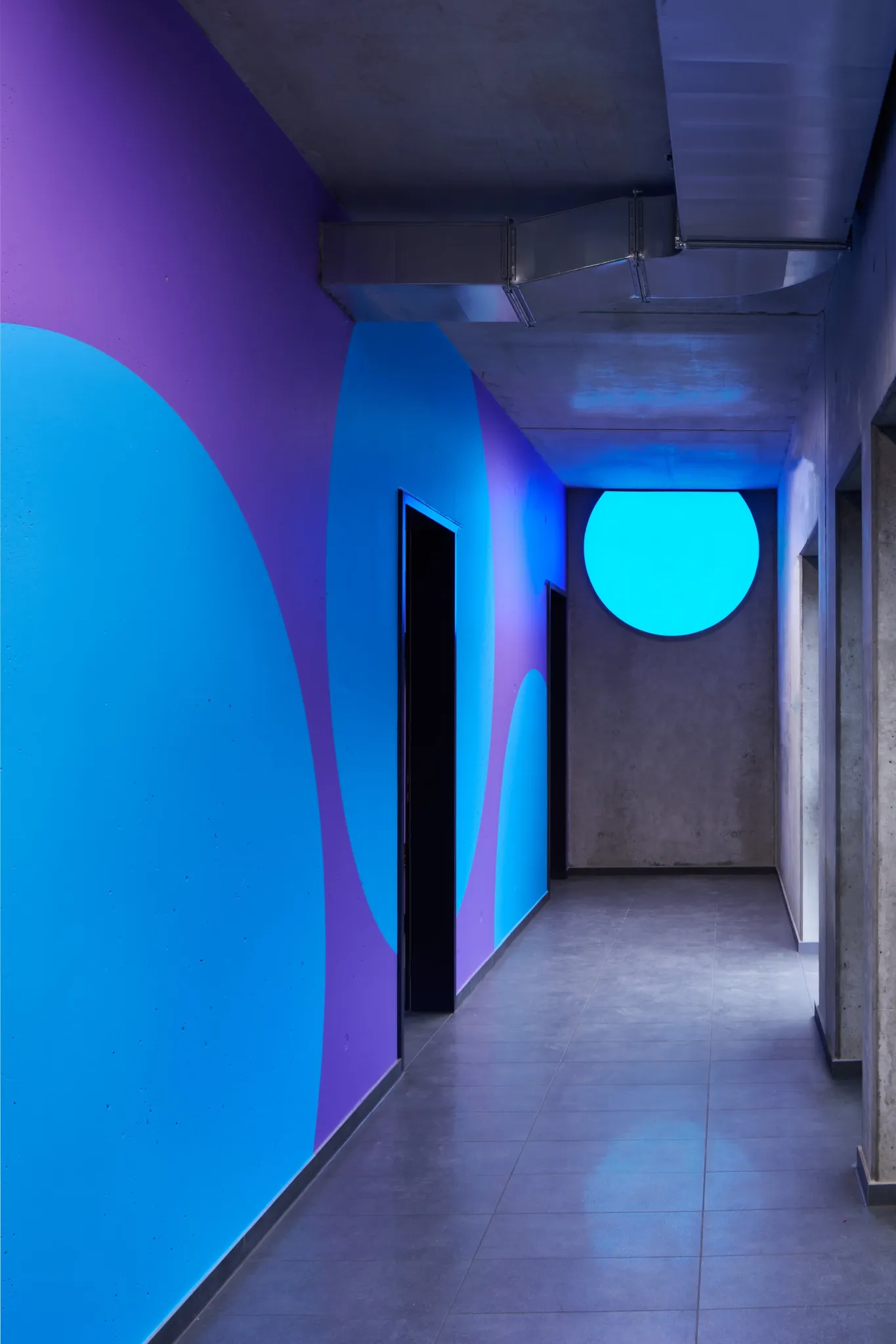 Blue and purple illuminated corridor with a circular landmark