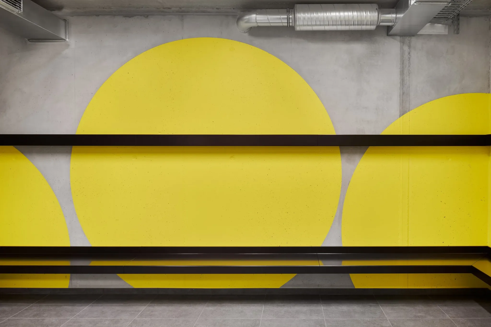 Yellow circular forms across concrete walls